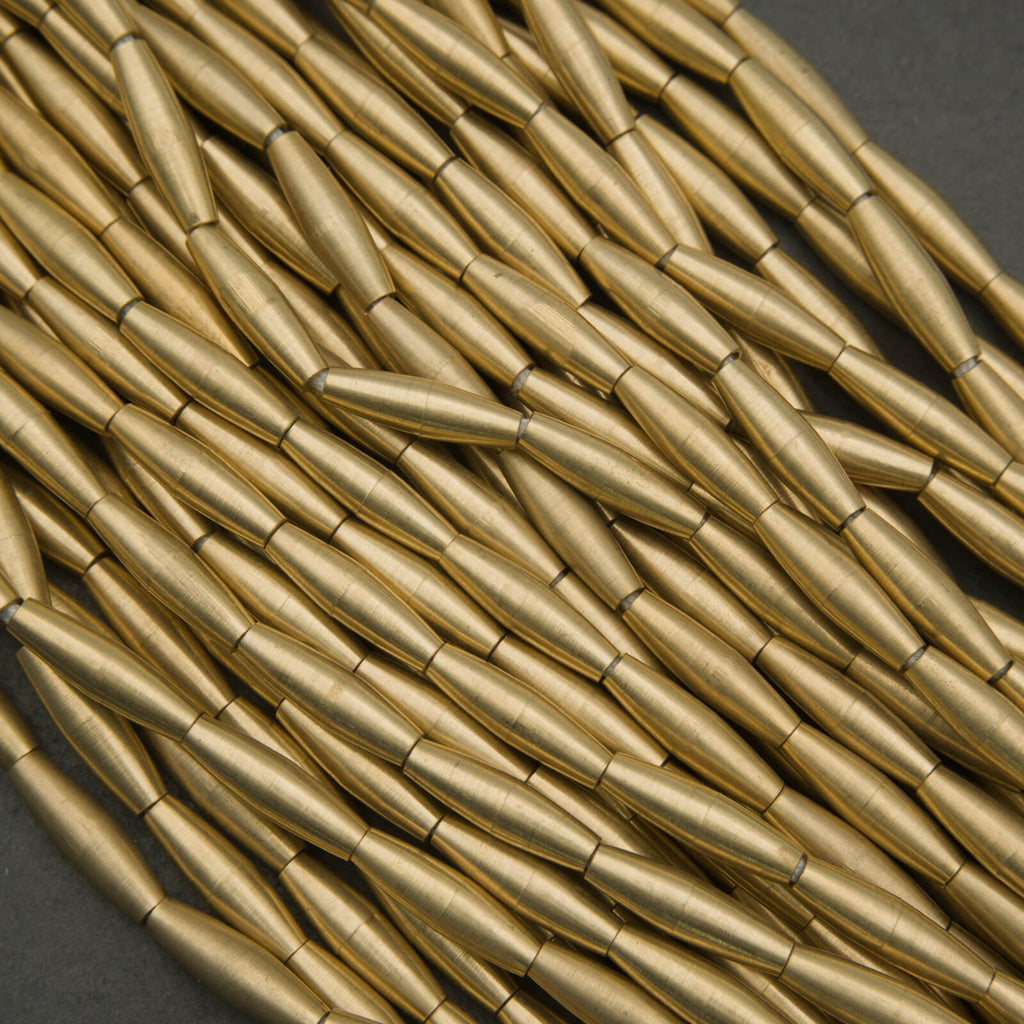 Close-up of gold cylindrical beads on a dark background