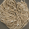 Close-up of a string of small metallic beads on a gray background