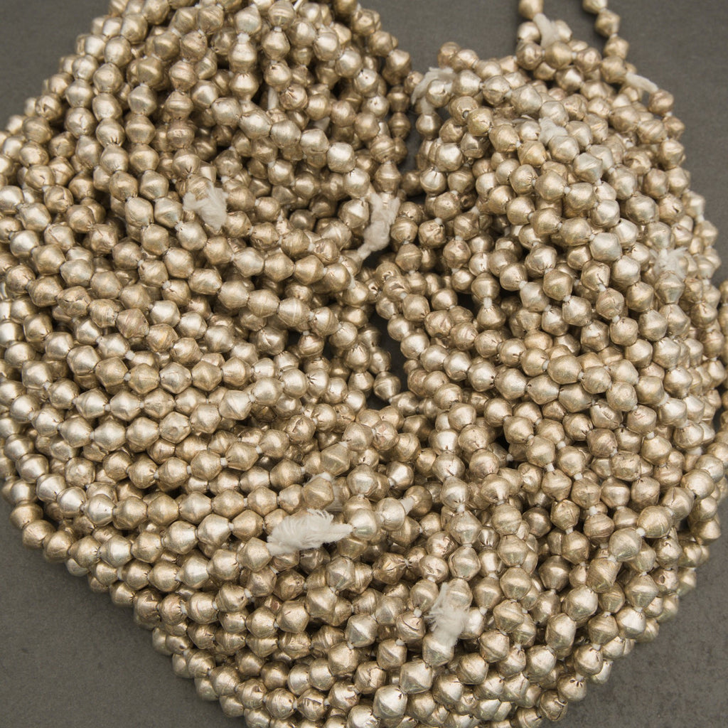 Close-up of a string of small metallic beads on a gray background