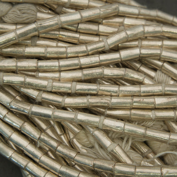 Close-up of metallic cylindrical beads on a dark background