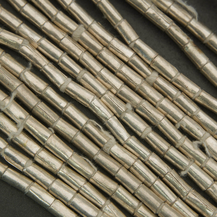 Close-up of metallic tubes arranged in a pattern on a dark background