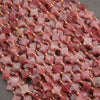 Natural strawberry quartz gemstone beads featuring four-petal floral shapes and delicate inclusions.