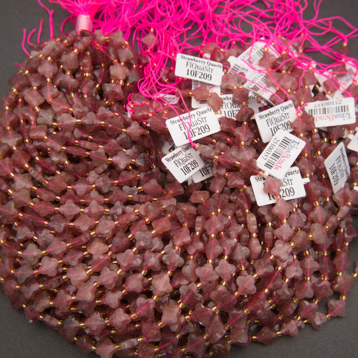 Close-up of strawberry quartz clover beads displaying dusty pink hues and natural mineral inclusions.