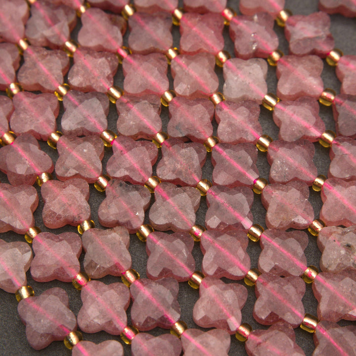 Strands of faceted strawberry quartz flower beads in muted rose and mauve shades with gold spacers.