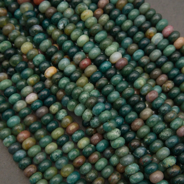 Close-up of green and brown beads on a gray background