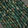 Close-up of green and brown beads on a gray background