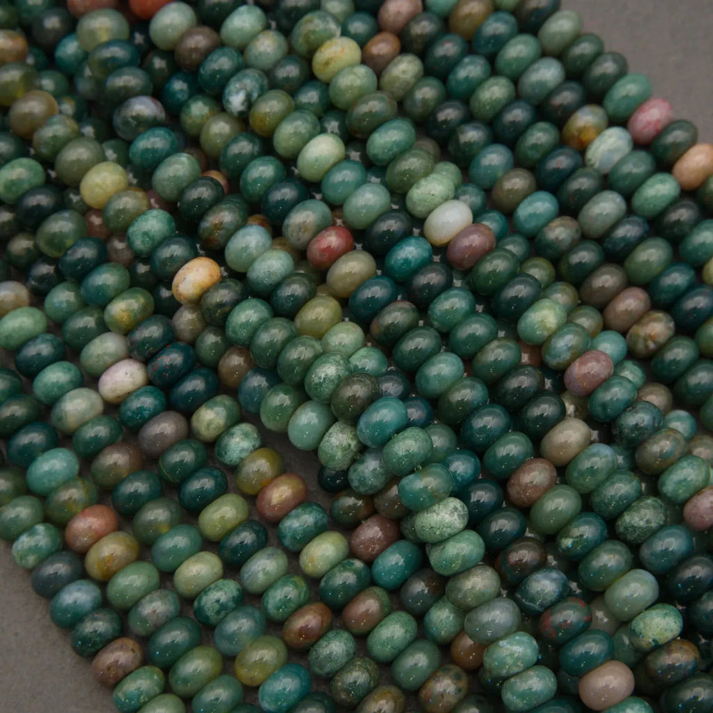 Close-up of green and brown beads on a gray background