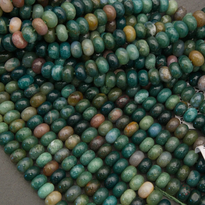 Close-up of green and brown beads on a gray surface