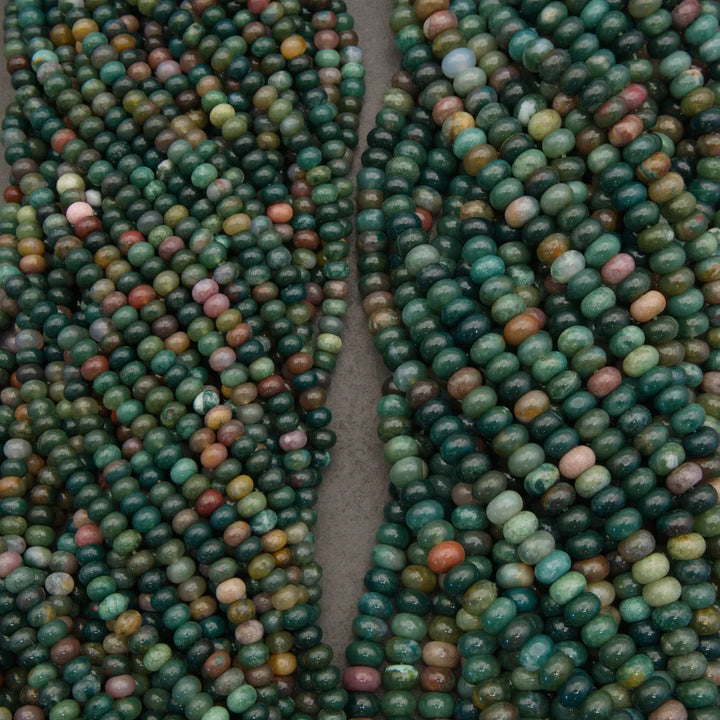 Close-up of two strands of multicolored beads on a gray background
