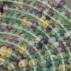 Smooth multicolor fluorite beads displaying shades of mint green, lavender, aqua blue, and golden yellow.