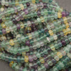 Multicolor fluorite rondelle beads featuring translucent green, purple, lavender, and golden-yellow tones.