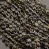 A heap of faceted golden obsidian star bead strands in smoky black and charcoal with gold seed bead spacers