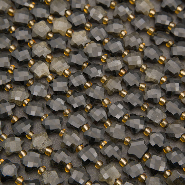Close-up of faceted golden obsidian star beads showing checkerboard facets and a golden sheen