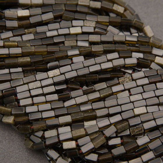 Golden obsidian rectangular beads featuring glossy black surfaces and a subtle metallic gold shimmer.