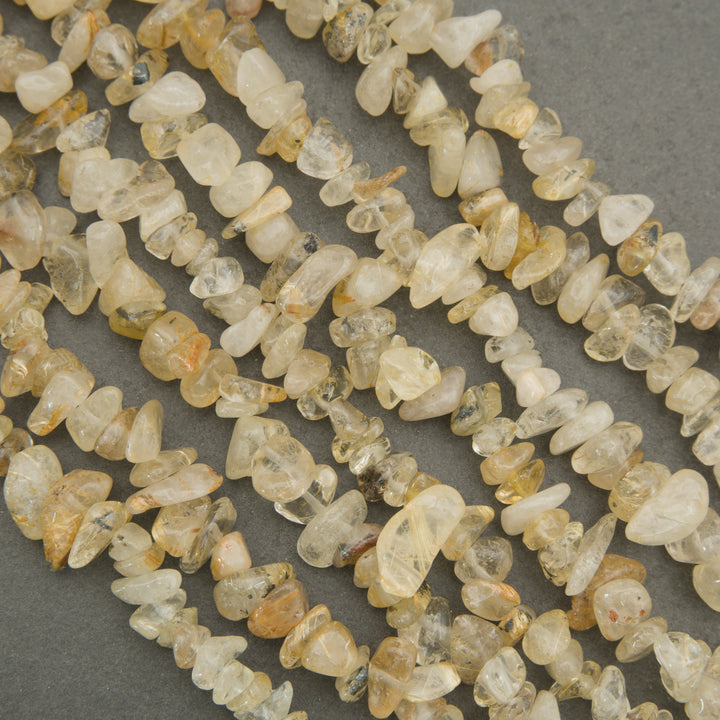 Close-up of a string of small, light-colored stones on a gray background