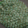 Pale green aventurine beads with faceted surfaces and charming four-leaf clover designs.