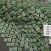 Close-up of mint-green aventurine flower beads with subtle natural color variations.