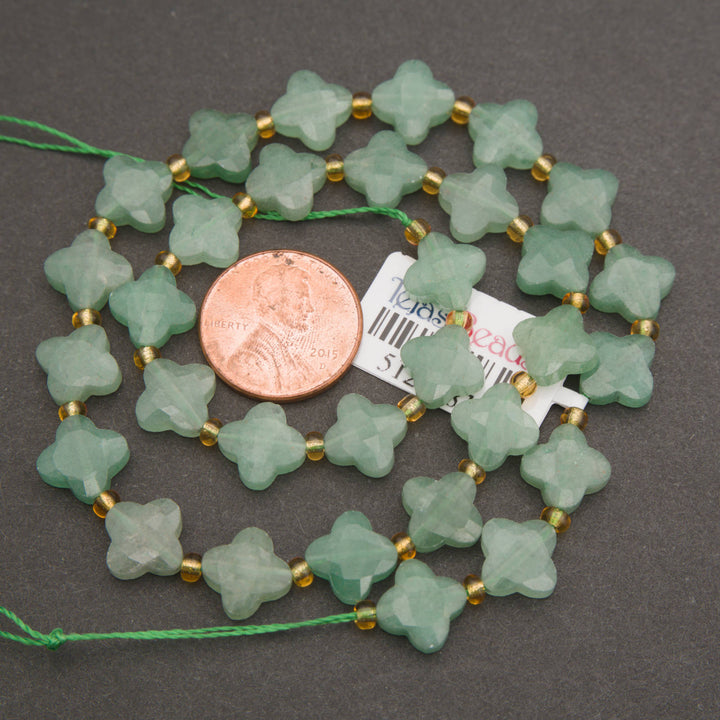 Light sage-green aventurine beads featuring faceted clover shapes and a smooth, frosted texture.