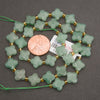 Light sage-green aventurine beads featuring faceted clover shapes and a smooth, frosted texture.