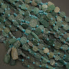 Green and blue beaded necklace on a dark surface