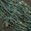 Green and blue beaded necklace on a dark surface