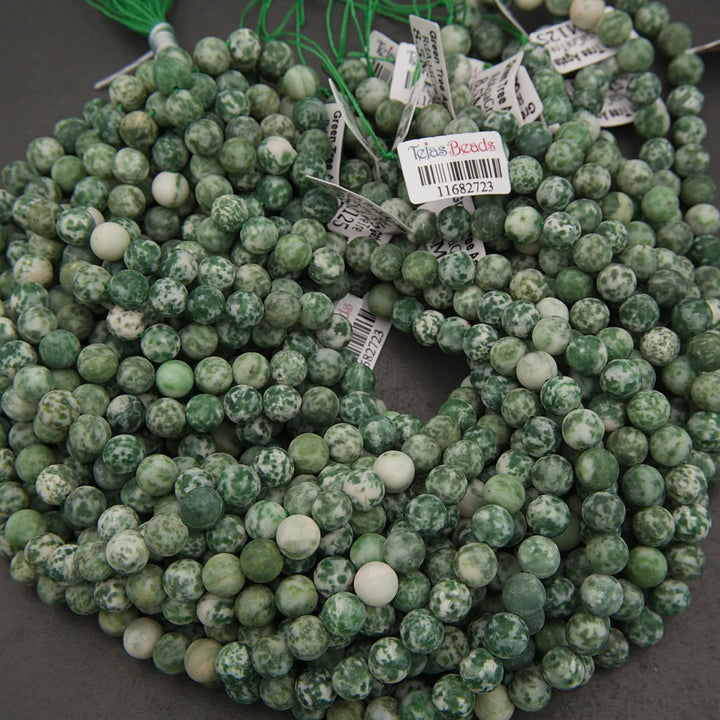 String of green beads with price tags on a dark surface