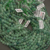 Green beads with labels on a gray surface