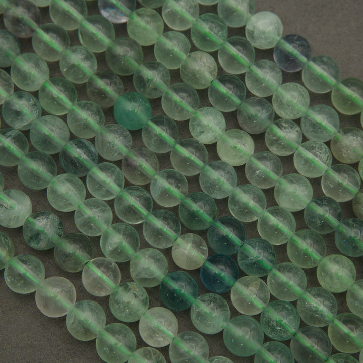 Close-up of green beads on a string with a dark background