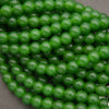 Close-up of smooth round green jade large hole beads in a glossy deep emerald green