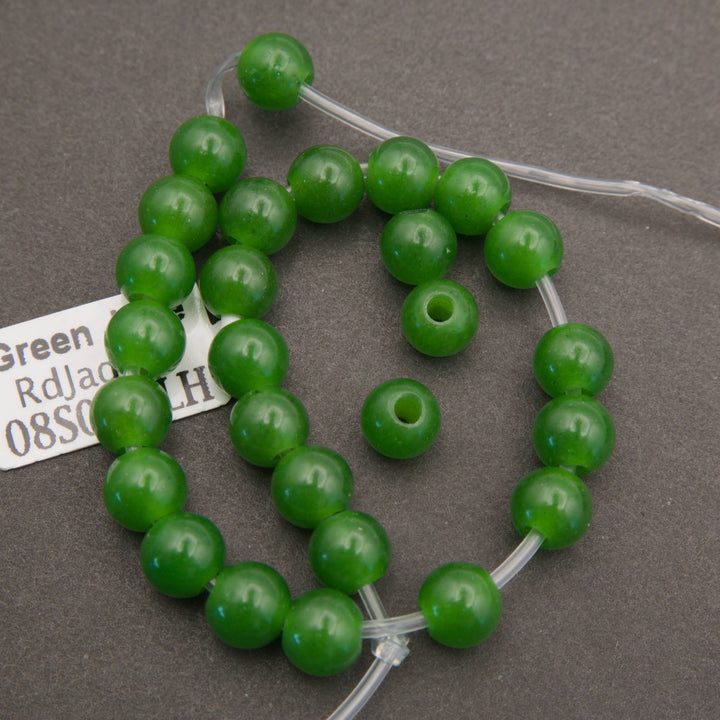A half strand of green jade large hole beads with its tag, showing the wide bead holes