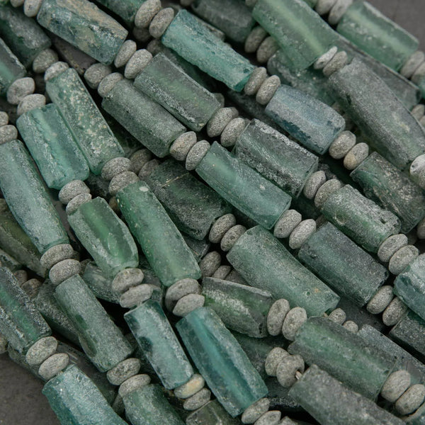 Close-up of green cylindrical beads on a dark background