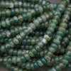 Close-up of green beads on a dark background