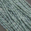 Close-up of green beads with silver spacers on a dark background
