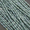 Close-up of green beads with silver spacers on a dark background