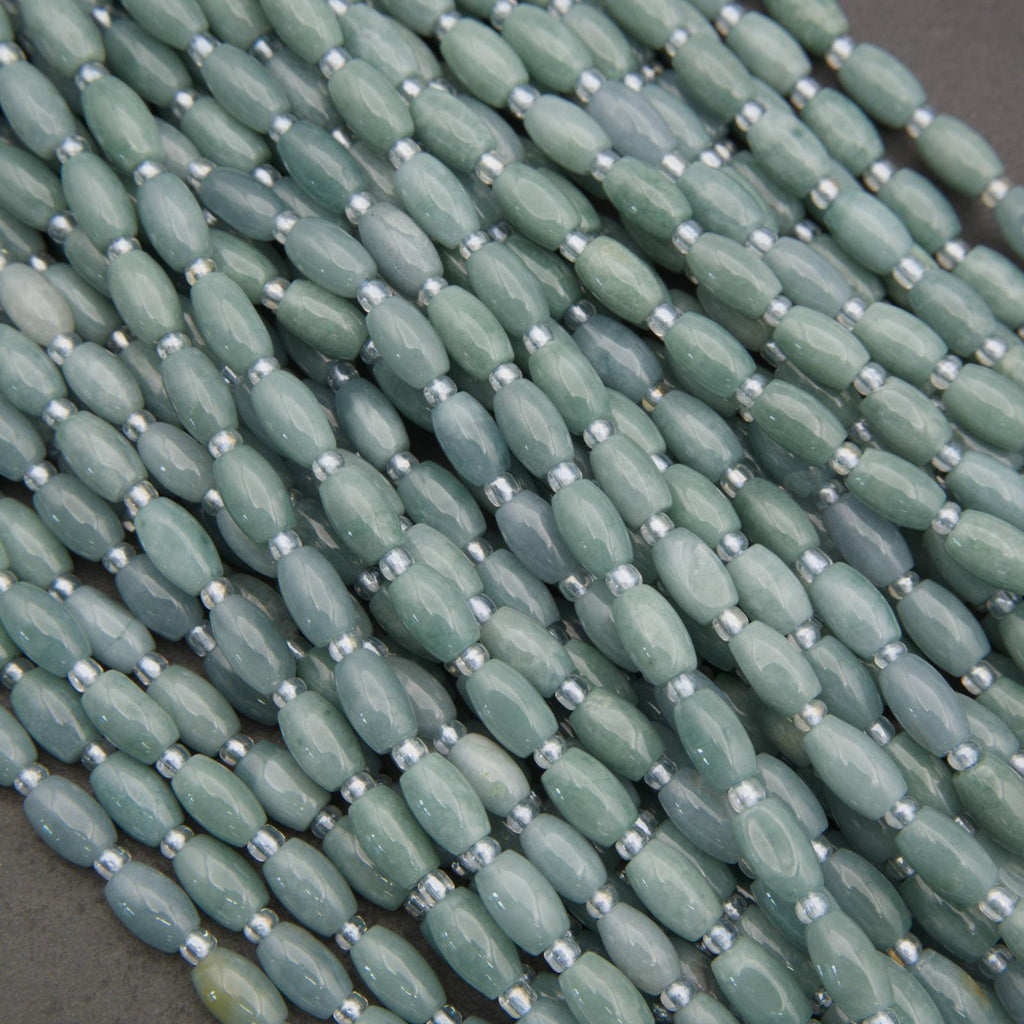 Close-up of green beads with silver spacers on a dark background