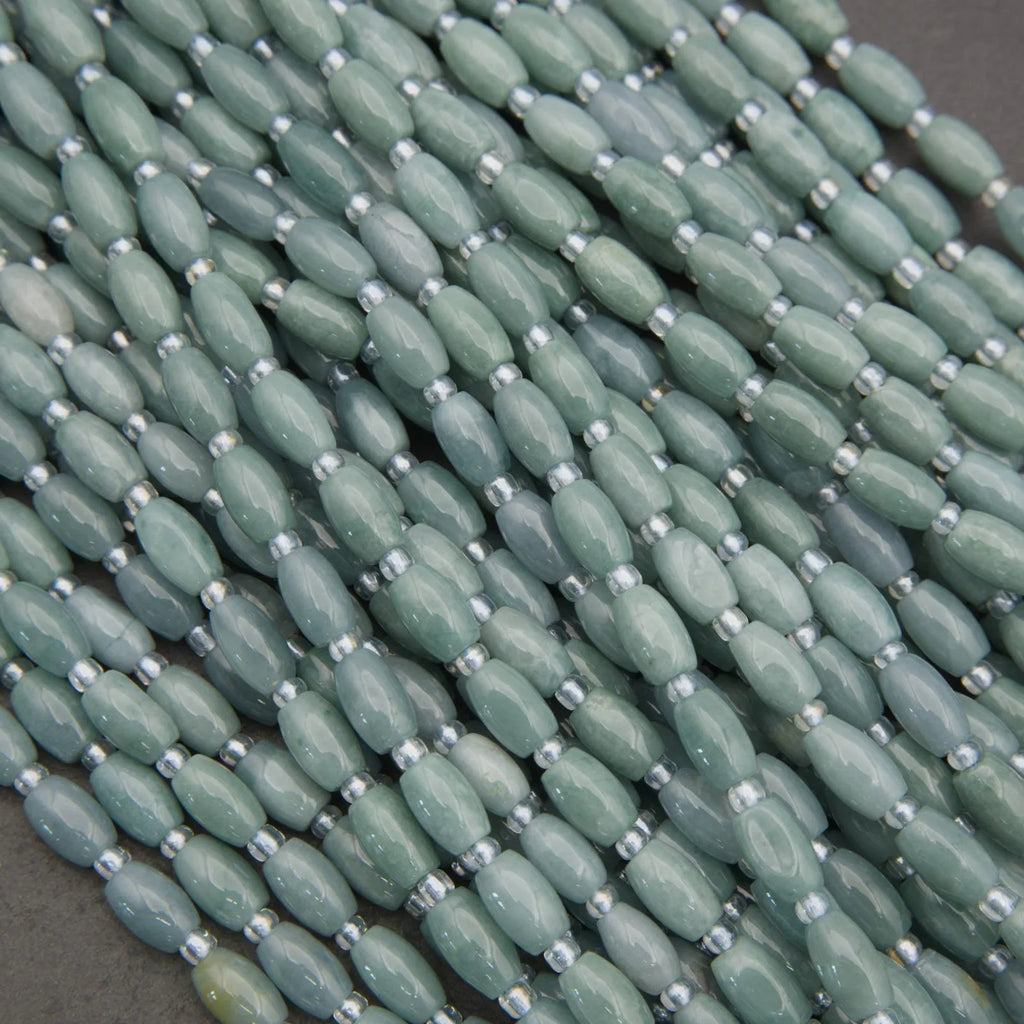 Close-up of green beads with silver spacers on a dark background