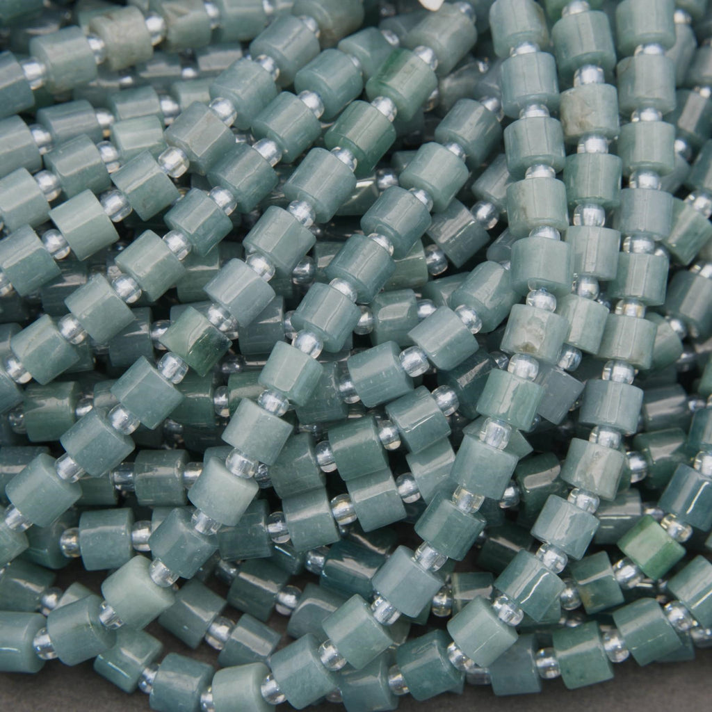 Close-up of green beads with silver accents on a gray background