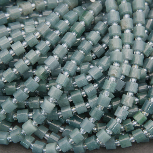 Close-up of green beads with silver accents on a gray background