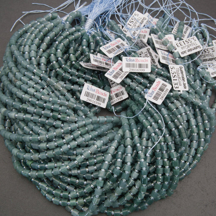 Green beads with labels on a gray surface