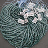 Green beads with labels on a gray surface