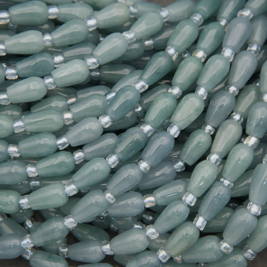 Close-up of green beads with silver caps on a dark background