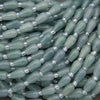 Close-up of green beads with silver caps on a dark background