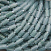 Stack of green plastic caps with metal inserts on a dark background