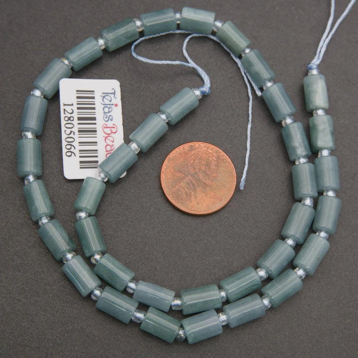 Beaded necklace with a penny for scale on a gray background
