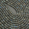 Close-up of a string of dark green beads with a gray background