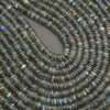 Close-up of a string of dark green beads with a gray background