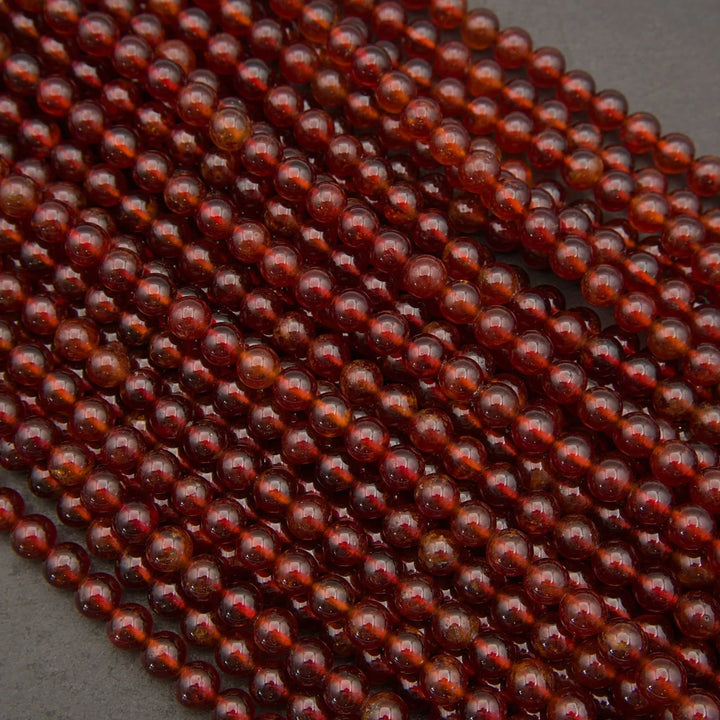 Polished Hessonite Garnet round beads with translucent cinnamon-red color