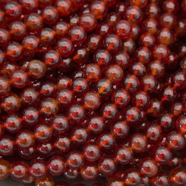 Natural Hessonite Garnet round gemstone bead strands in rich reddish-brown hues