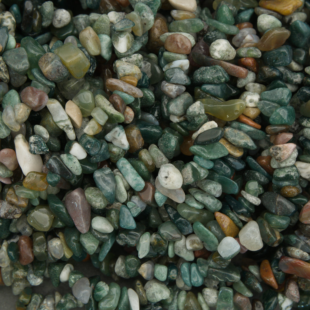 Close-up of small pebbles with various colors including green, brown, and white.