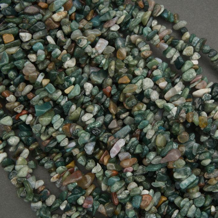 Close-up of a string of small, multicolored stones on a gray background